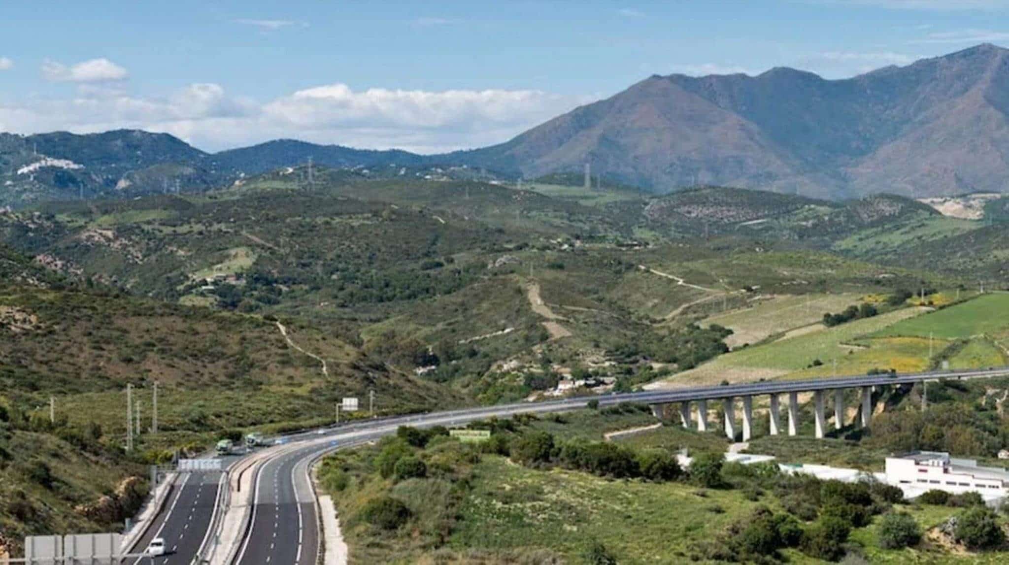 Highway stretching out into the countryside with mountains in background