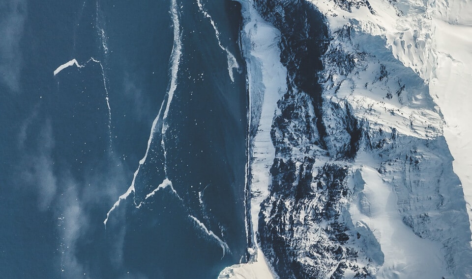 Aerial view of waves crashing into ice