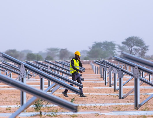 African man servicing solar panels