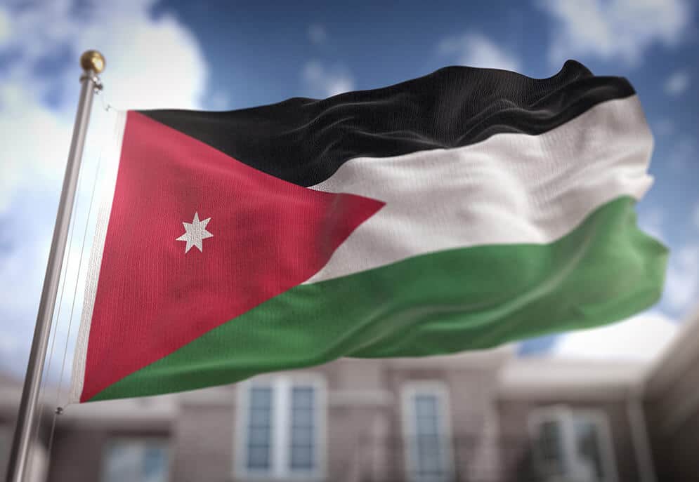 Flag of Jordan flying in front of a building
